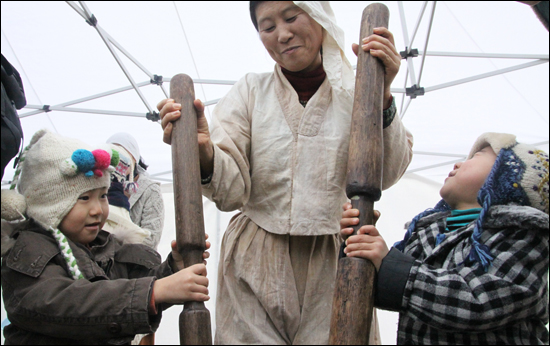 축제장에 마련된 떡 만들기 행사장에서 '쿵딱 쿵딱!' 고사리 손으로 직접 떡메를 치는 어린이들. ⓒ제주의소리