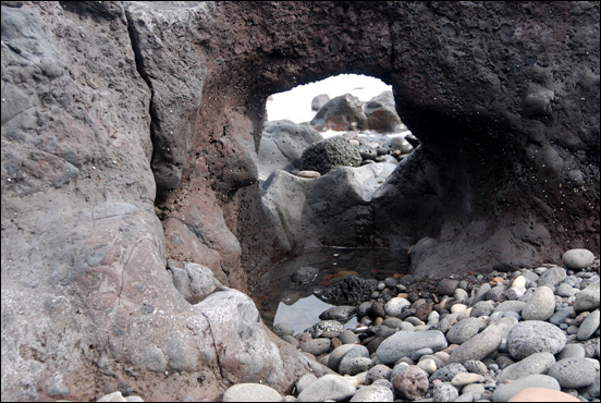 화산암 암맥의 약한 부분이 파도의 침식으로 인해 구멍이 뚫여 시아치(sea arch)가 형성되었다.