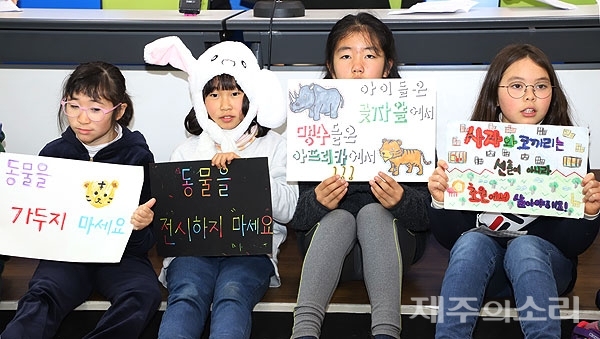 함덕초등학교 선인분교 학부모·학생들이 27일 오전 열린 기자회견장에서 제주동물테마파크사업 중단을 촉구하는 피켓을 들고 있다.ⓒ제주의소리