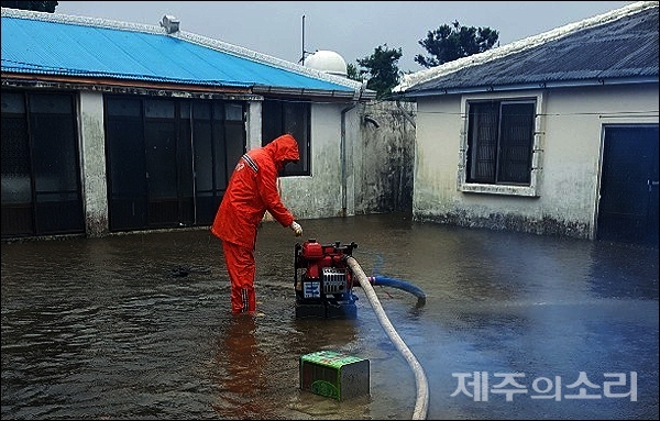 19일 저녁 서귀포시 성산읍 시흥리의 한 주택과 마당이 물에 잠겨 119대원들이 배수 작업을 벌이고 있다. [사진제공-제주동부소방서]