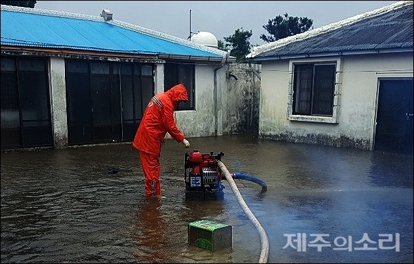 19일 저녁 서귀포시 성산읍 시흥리의 한 주택과 마당이 물에 잠겨 119대원들이 배수 작업을 벌이고 있다. 사진=제주동부소방서