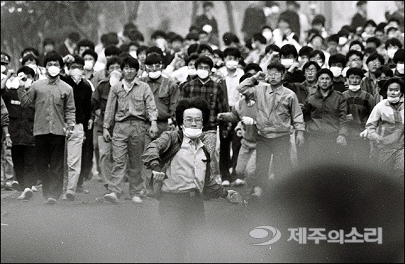 김기삼 작가가 촬영한 1989년 제주대학교에서 벌어진 민주화운동의 모습. 한 대학생이 경찰을 향해 화염병을 던지고 있다. ⓒ제주의소리 자료사진