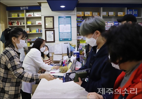 한정애 약사(왼쪽 흰색 약사복)가 신분증 확인과 함께 마스크를 1인당 2매씩 판매하고 있다.