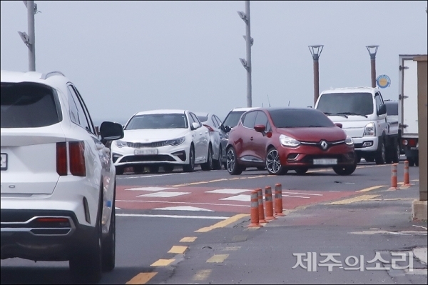제주시 용담동 해안도로에서 빨간 차량이 중앙선을 침범해 불법 좌회전하고 있다. ⓒ제주의소리 자료사진