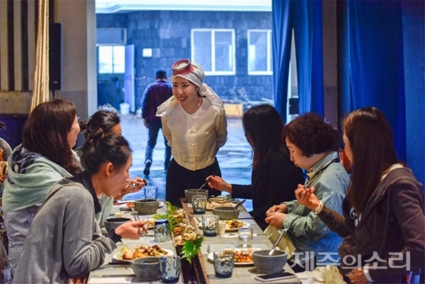 해녀의 부엌은 싱싱한 해산물과 함께 해녀들의 이야기를 담은 퍼포먼스를 선보인다. 입과 눈, 귀가 함께 즐거운 특별한 경험을 제공한다. 사진은 고객들과 대화 중인 해녀의 부엌 김하원 대표. /사진 제공=해녀의 부엌 ⓒ제주의소리