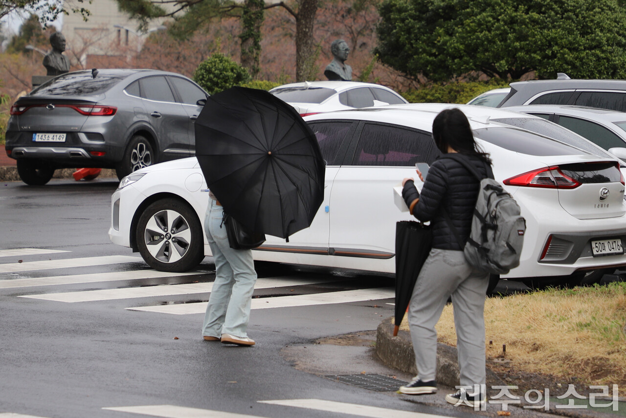 25일 오후 제주대학교 캠퍼스를 걷는 학생 우산이 강한 바람에 뒤집혔다. ⓒ제주의소리