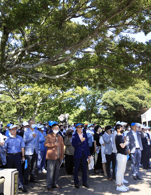 참석자들이 나무 그늘 아래에서 국가에 대한 경례를 하고 있다. ⓒ제주의소리