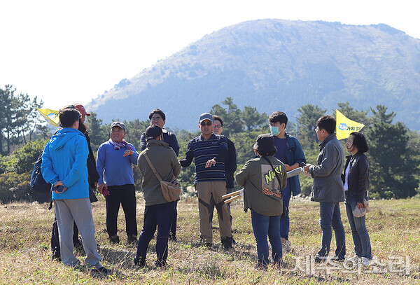 고홍기 이장과 김홍관 계장이 평대공동목장에 대해 설명하고 있다. 그 뒤로는 돗오름(돝오름)이 보인다.&nbsp;ⓒ제주의소리