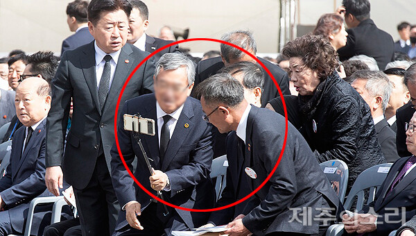 묵념이 끝난후 동백꽃이 아닌 다른 배지를 착용한 한 인사가 추념식장에 난입해 한덕수 국무총리와 셀카 촬영을 시도하고 있다.&nbsp;