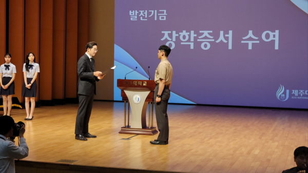 한라산 현재웅 대표가 25일 제주대 우수학생 12명에게 장학금을 전달하고 있다.
