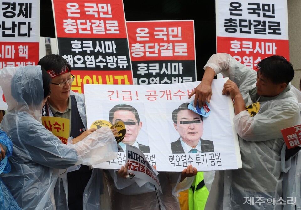 윤석열 정권 퇴진 한국사회 대전환 제주행동이 오전 11시 주제주일본국총영사관 앞에서 기시다 후미오 일본 총리와 윤석열 대통령 사진에 방사능 스티커를 붙이는 퍼포먼스를 보이고 있다. ⓒ제주의소리