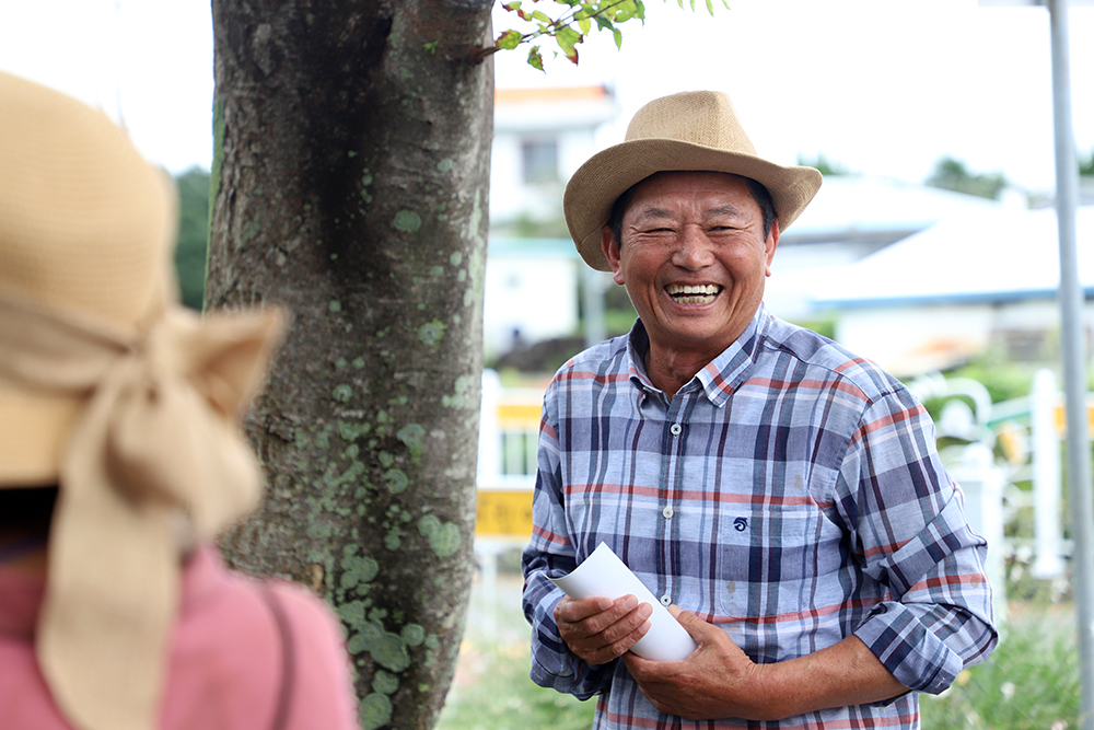 2일 열린 나비마을 영천동네커리 테스트투어. 영촌동 농촌중심지활성화 추진위원장을 맡고 있는 토박이 오홍부(72)씨가 참가자들과 대화하며 환하게 웃고 있다. ⓒ제주의소리