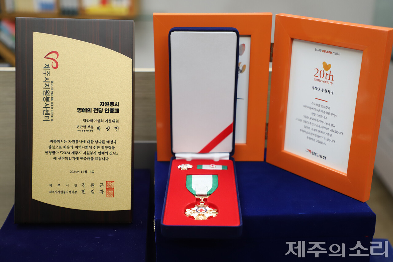 제주시 자원봉사 명예의전당 인증패와 50회 이상 헌혈자에게 지급하는 금장, 월드비전 20년 후원 감사패. 아래로도 수많은 감사패와 공로패 등이 쌓여 있다. ⓒ제주의소리