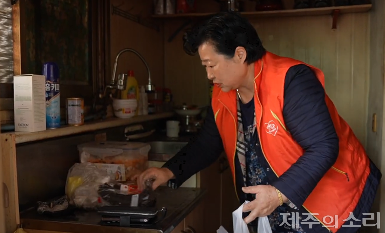 올로 사는 어르신 집을 찾아 청소하고 반찬을 만들어 냉장고에 담는 등 봉사활동 중인 문 원장. 사진=제주시자원봉사센터 유튜브 갈무리. ⓒ제주의소리