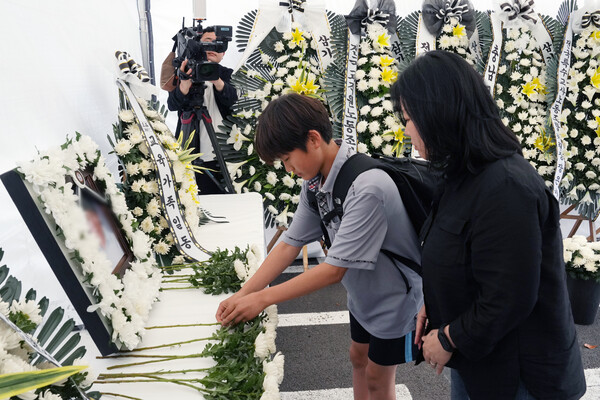 23일 오후 제주도교육청에 마련된 분향소. A씨 영정사진 앞에 한 학생이 국화를 놓고 있다.