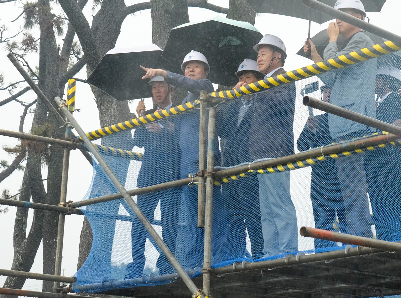 신례리 생태마을 공사 현장을 둘러보고 있는 황 신부와 오 지사. 사진=제주도.